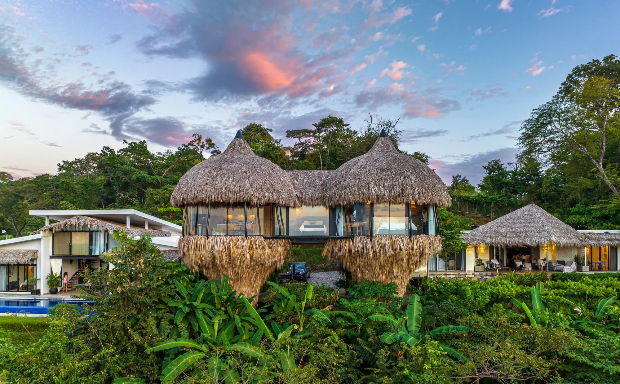 Cocoon Tamarindo — the estate seen from the air, with the thatched Nido suites in front